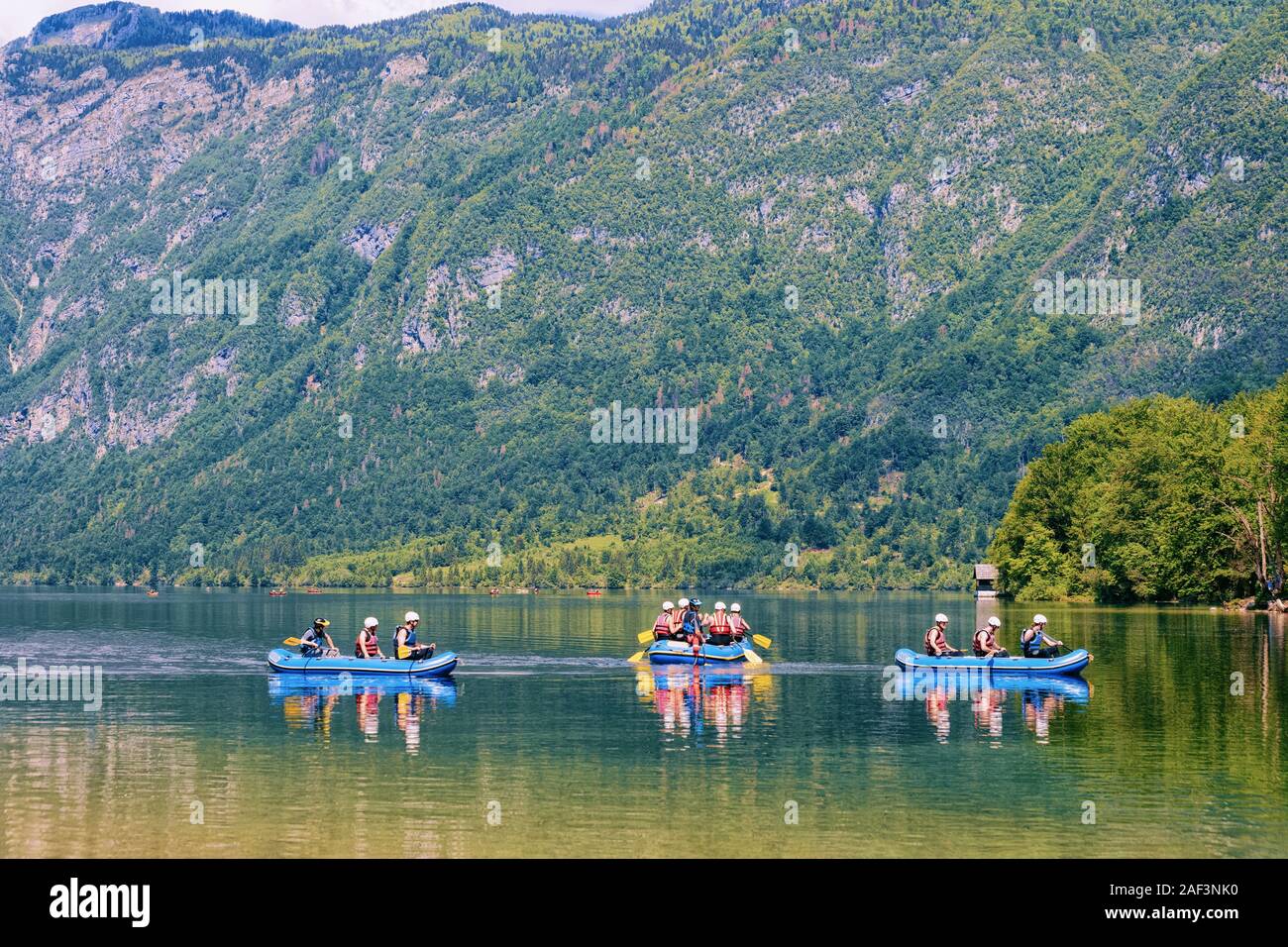 Paysage avec les gens du canoë sur le lac de Bohinj en Slovénie Banque D'Images