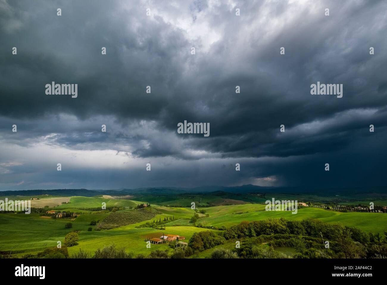 Vue panoramique d'un plat typique campagne toscane, dans le Val d'Orcia, la ferme Podere Belvedere sur une petite colline, sombres nuages d'orage dans l'isolation partiellechauffage Banque D'Images