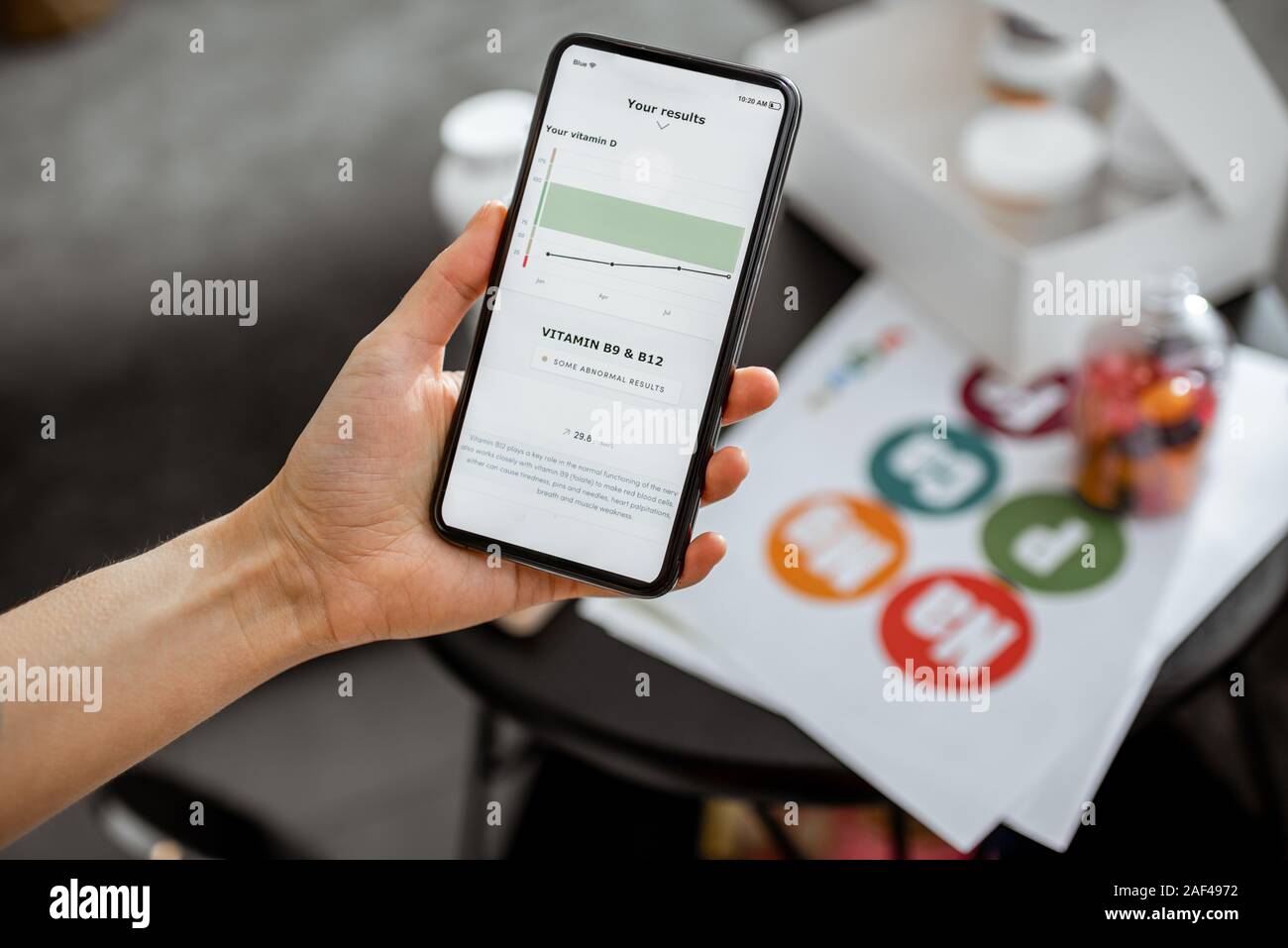 Contrôle de la femme suite de tests médicaux sur un smartphone, close-up avec des suppléments nutritionnels sur l'arrière-plan. Concept de l'individu en ligne Sélection de suppléments alimentaires Banque D'Images