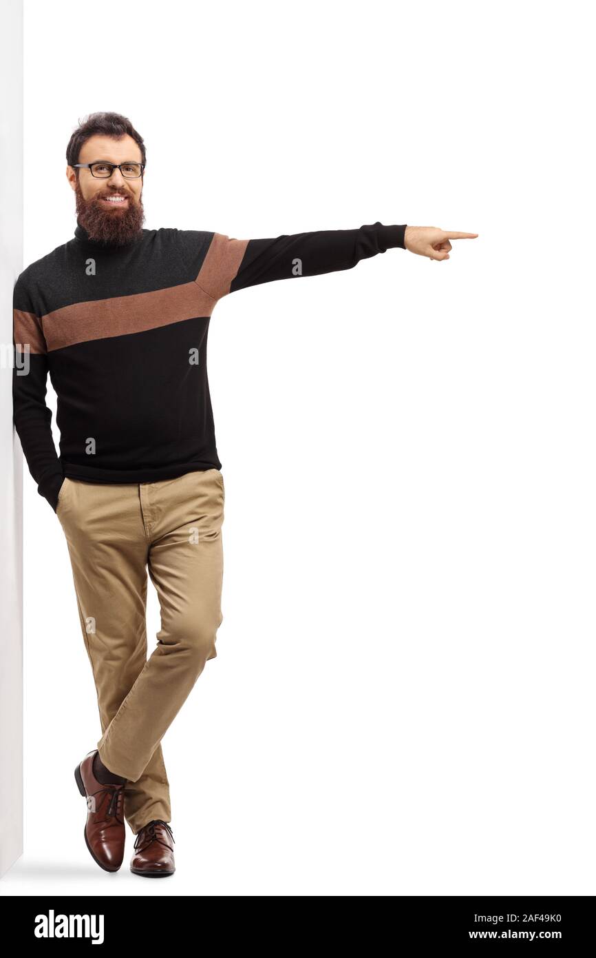 Portrait d'un homme barbu dans un Pull col roulé appuyée sur un mur et en faisant ressortir le côté isolé sur fond blanc Banque D'Images