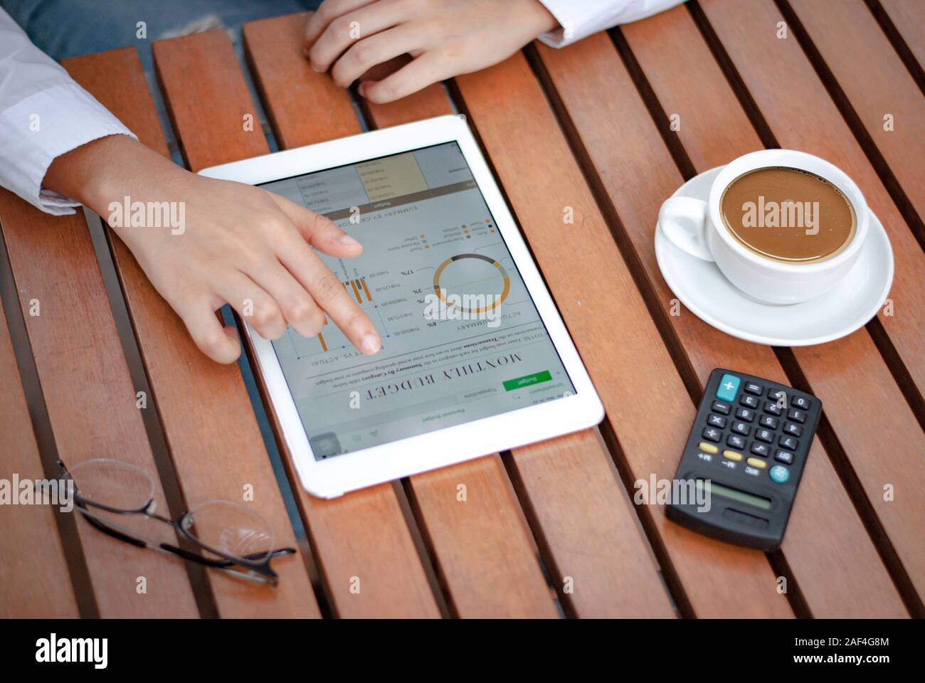 Gros plan des tablettes numériques dans les mains des femmes avec un concept de travail de tasse à café Banque D'Images