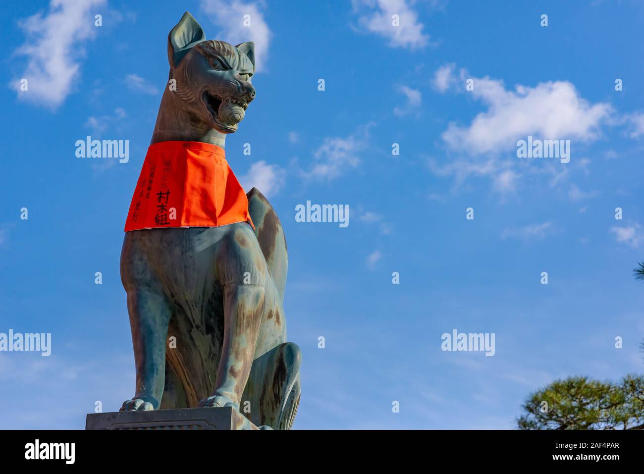 Kyoto, Japon - 24 mars 2017 : Fox statue au Sanctuaire Fushimi Inari, prises sous le soleil d'après-midi de printemps, avec ciel dans l'arrière-plan et sans peopl Banque D'Images