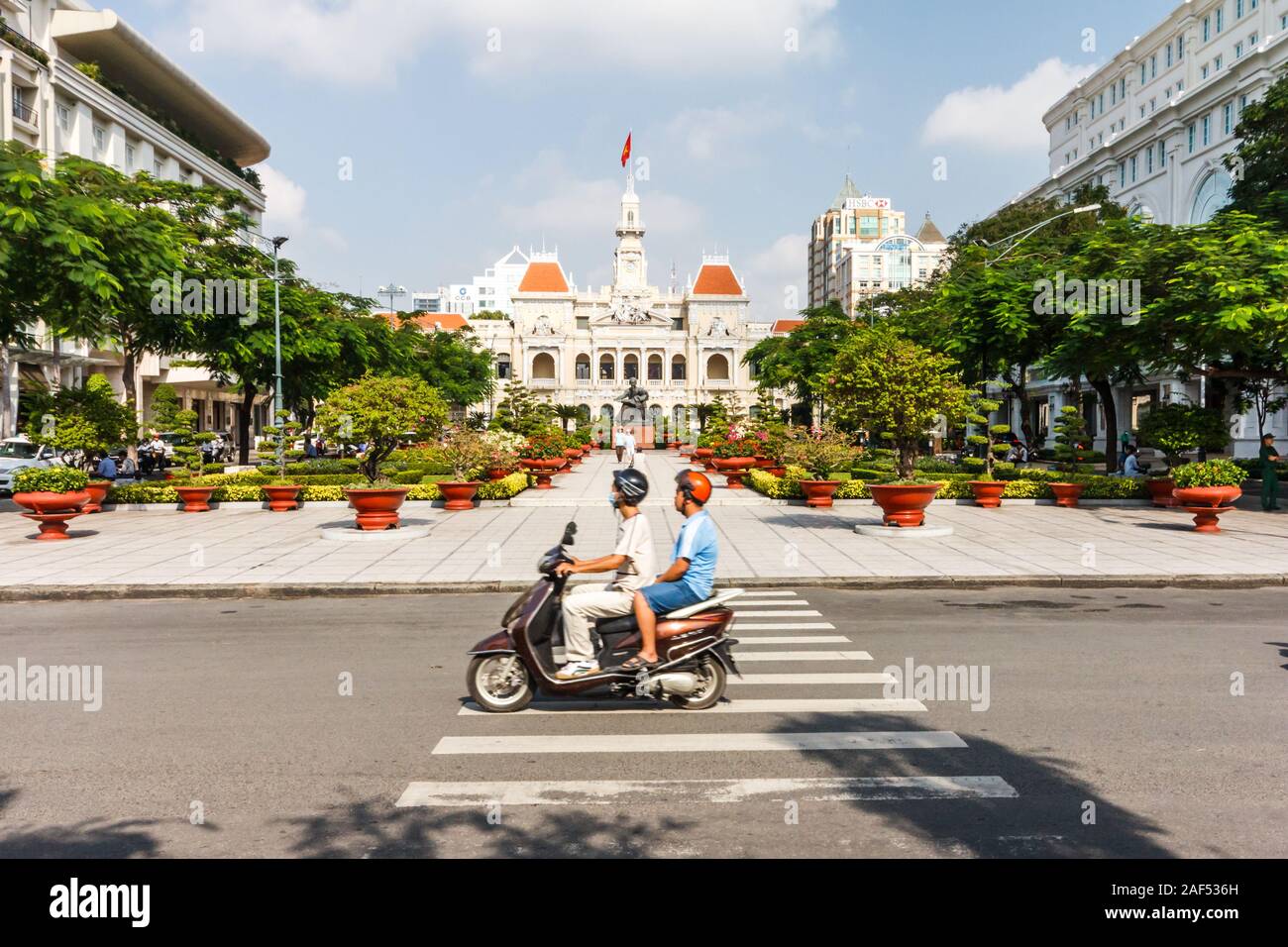 Ho Chi Minh Ville, Vietnam - 30 octobre 2013 : un motocycliste rides le long de la route. Dans l'arrière-plan sont les peuples Comité. Banque D'Images