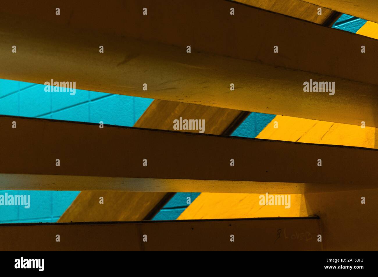 Géométrie abstraite d'un escalier - jaune et bleu et grafitty Banque D'Images