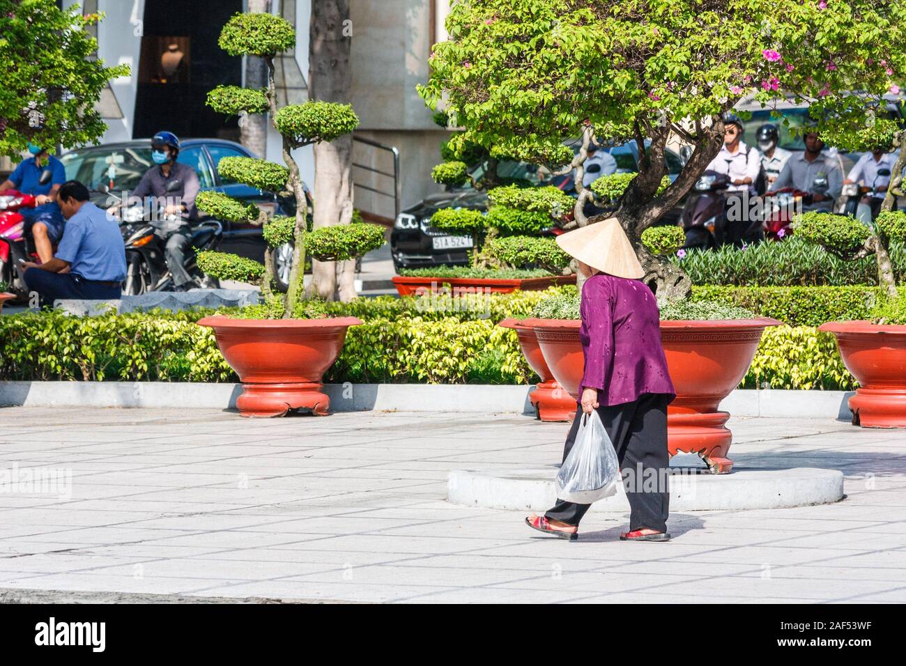 Ho Chi Minh Ville, Vietnam - 30 octobre 2013 : Femme en chapeau conique à marcher le long de la rue. Ce type de chapeau est populaire comme un pare-soleil. Banque D'Images