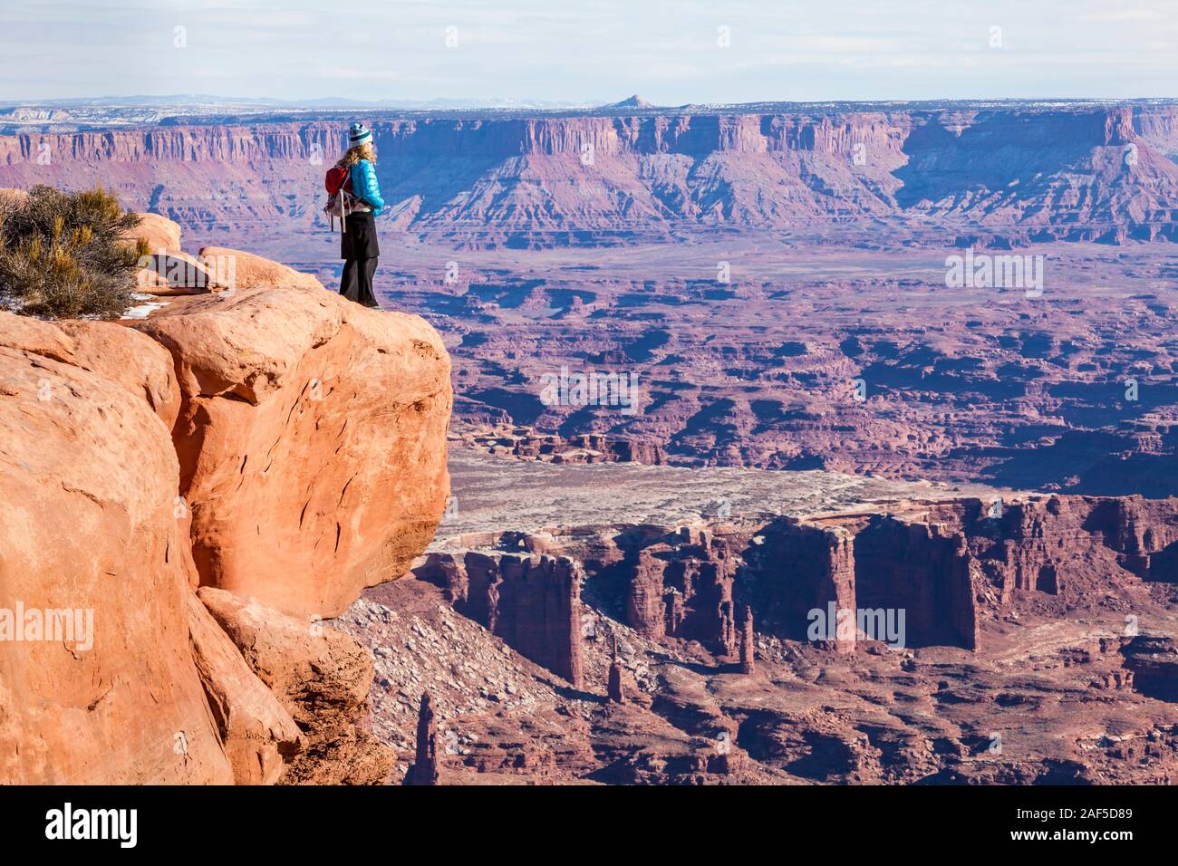 Une femme debout au bord du canyon en profitant de la vue spectaculaire. Island in the Sky, Canyonlands National Park, Utah, USA. Banque D'Images