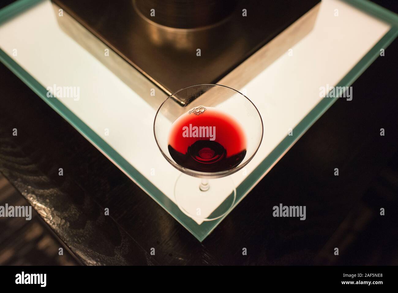 Un verre de vin assis sur une table éclairée dans un bar de Manhattan. Banque D'Images