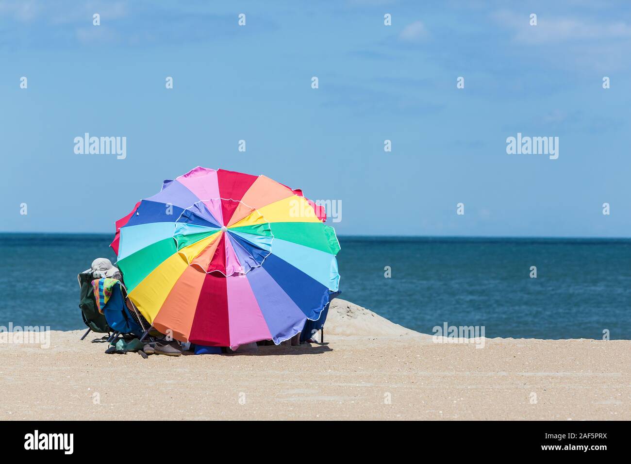 Avon, Outer Banks, Caroline du Nord. Parasol et de la famille sur la plage. Banque D'Images