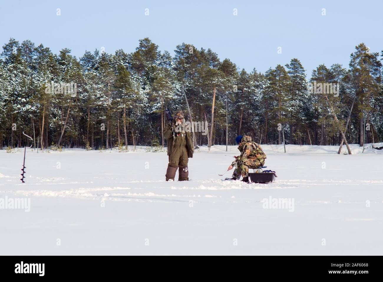 Frosty matin d'hiver la pêche sur la rivière. La pêche d'hiver. Vis de la glace près de Banque D'Images