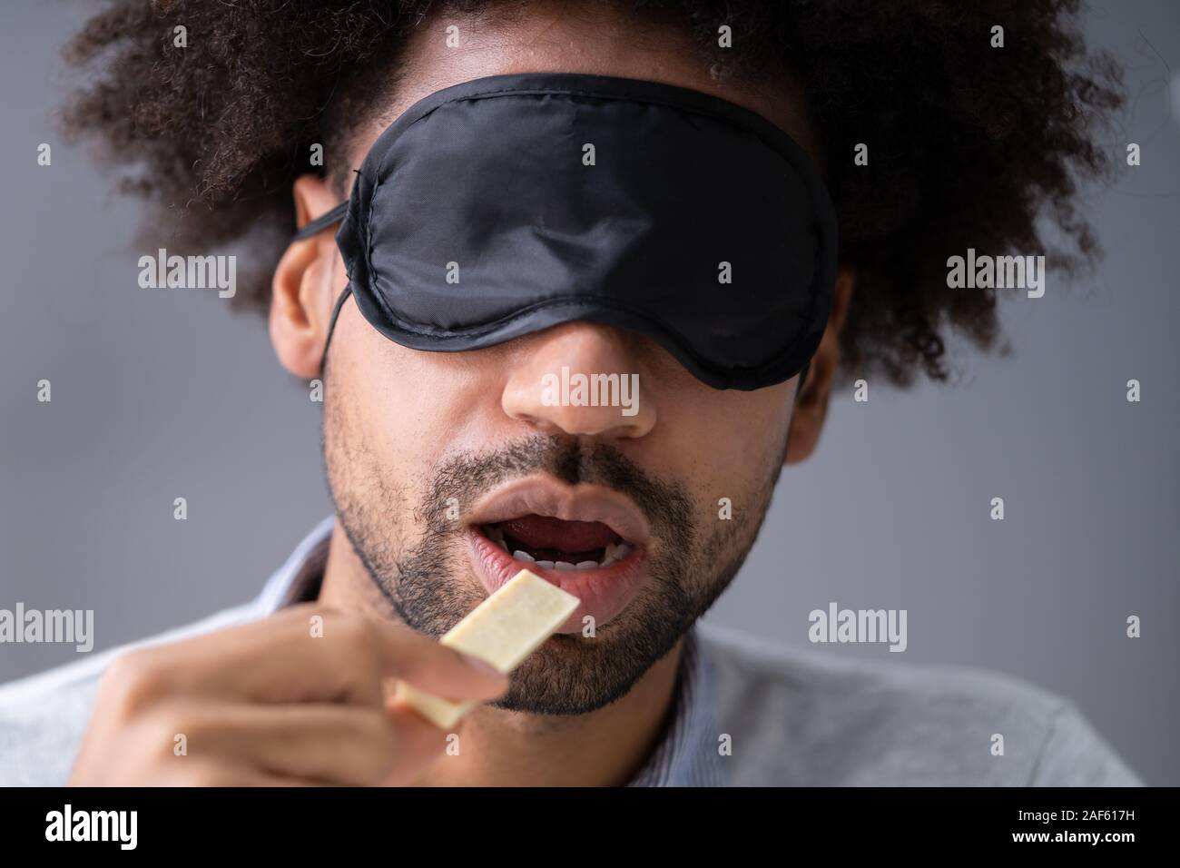 Portrait de jeune homme, les yeux bandés, l'alimentation à l'essai Banque D'Images