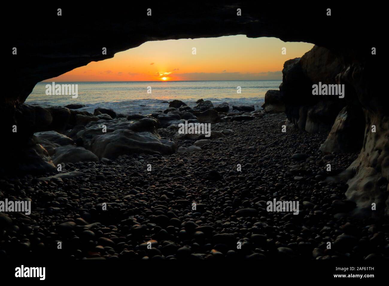 Grotte de la mer sous la tête de la bière sur la côte jurassique du Devon au lever du soleil Banque D'Images