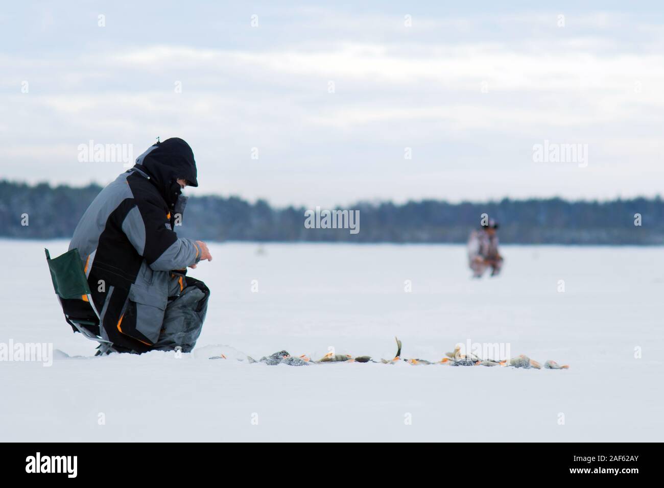 Frosty matin d'hiver la pêche sur la rivière. La pêche d'hiver. Vis de la glace près de Banque D'Images