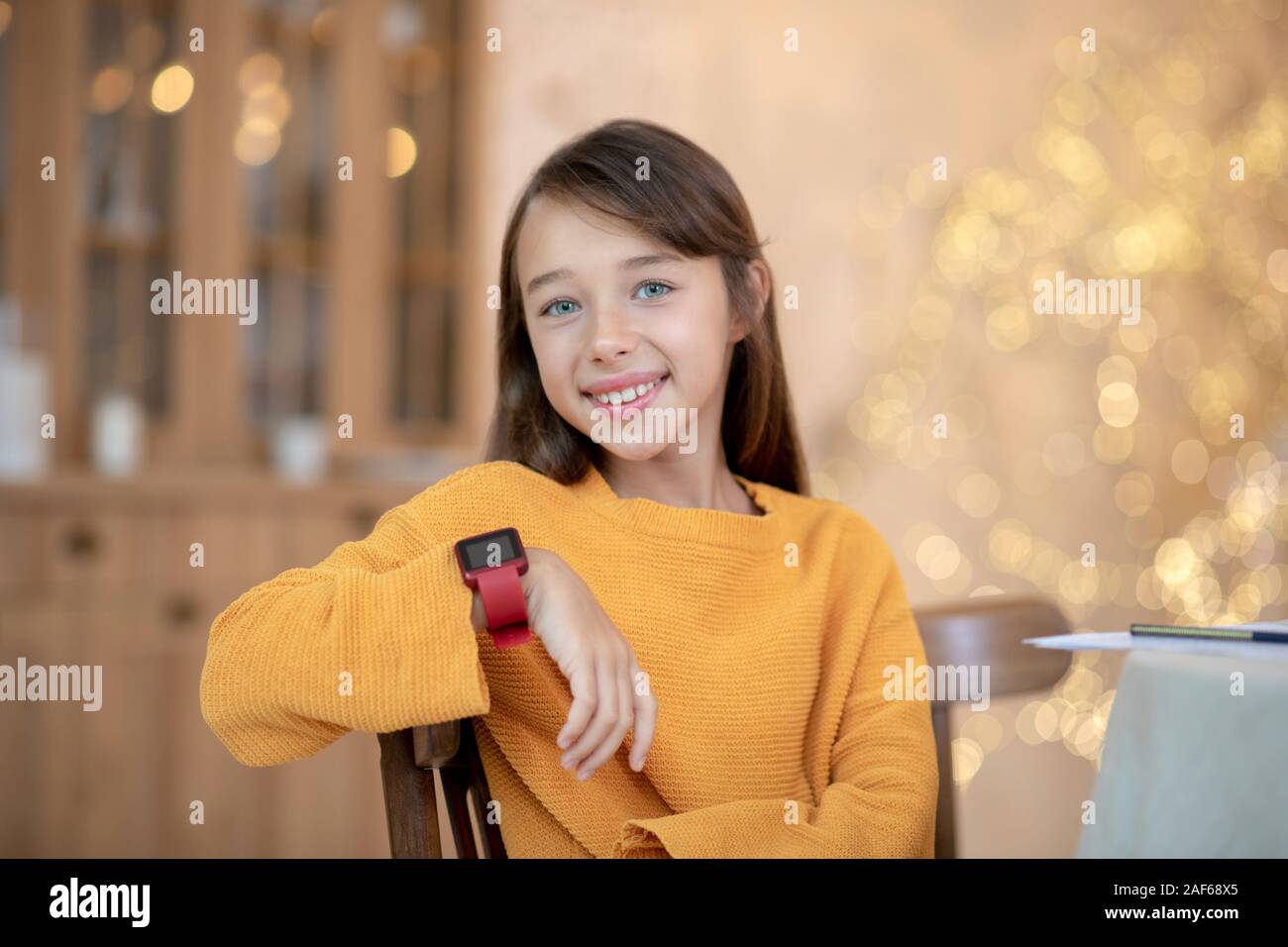 Cute girl en orange shirt smiling joliment Banque D'Images