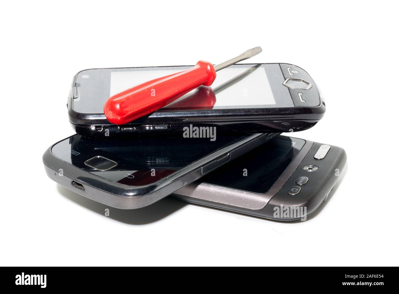 Réparation de trois smartphones noir et un tournevis isolé sur fond blanc Banque D'Images