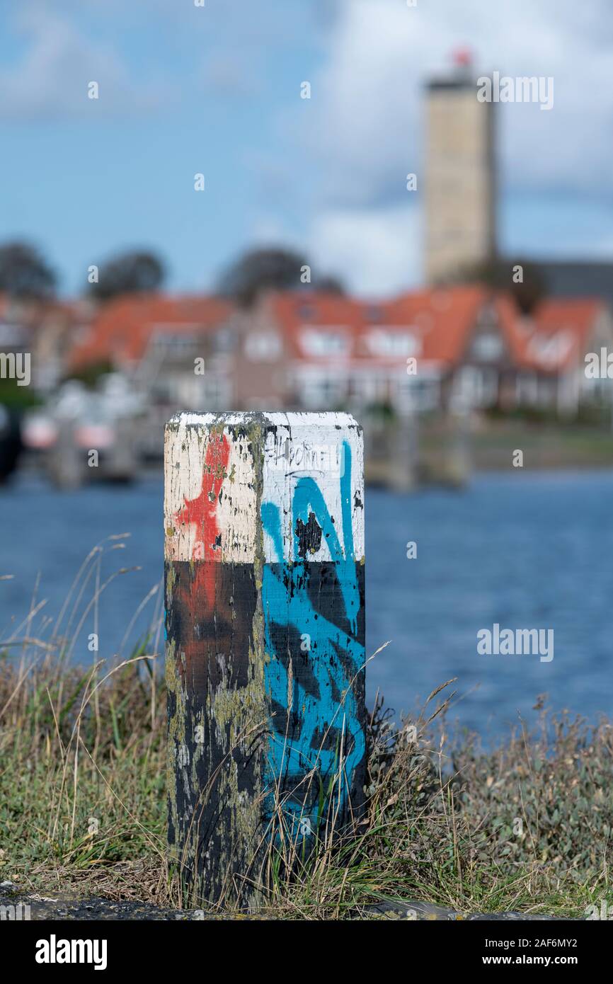 Bollard en bois multicolores sur la jetée du port du port de Terschelling. Banque D'Images