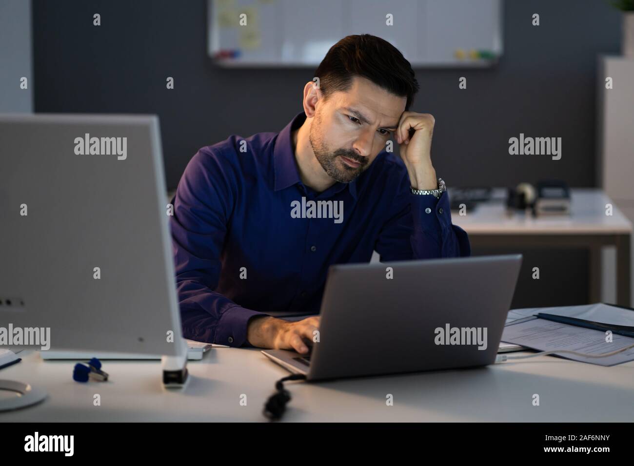 Comptable a souligné assis avec tête en main en travaillant à la fin de l'Office de Tourisme Banque D'Images