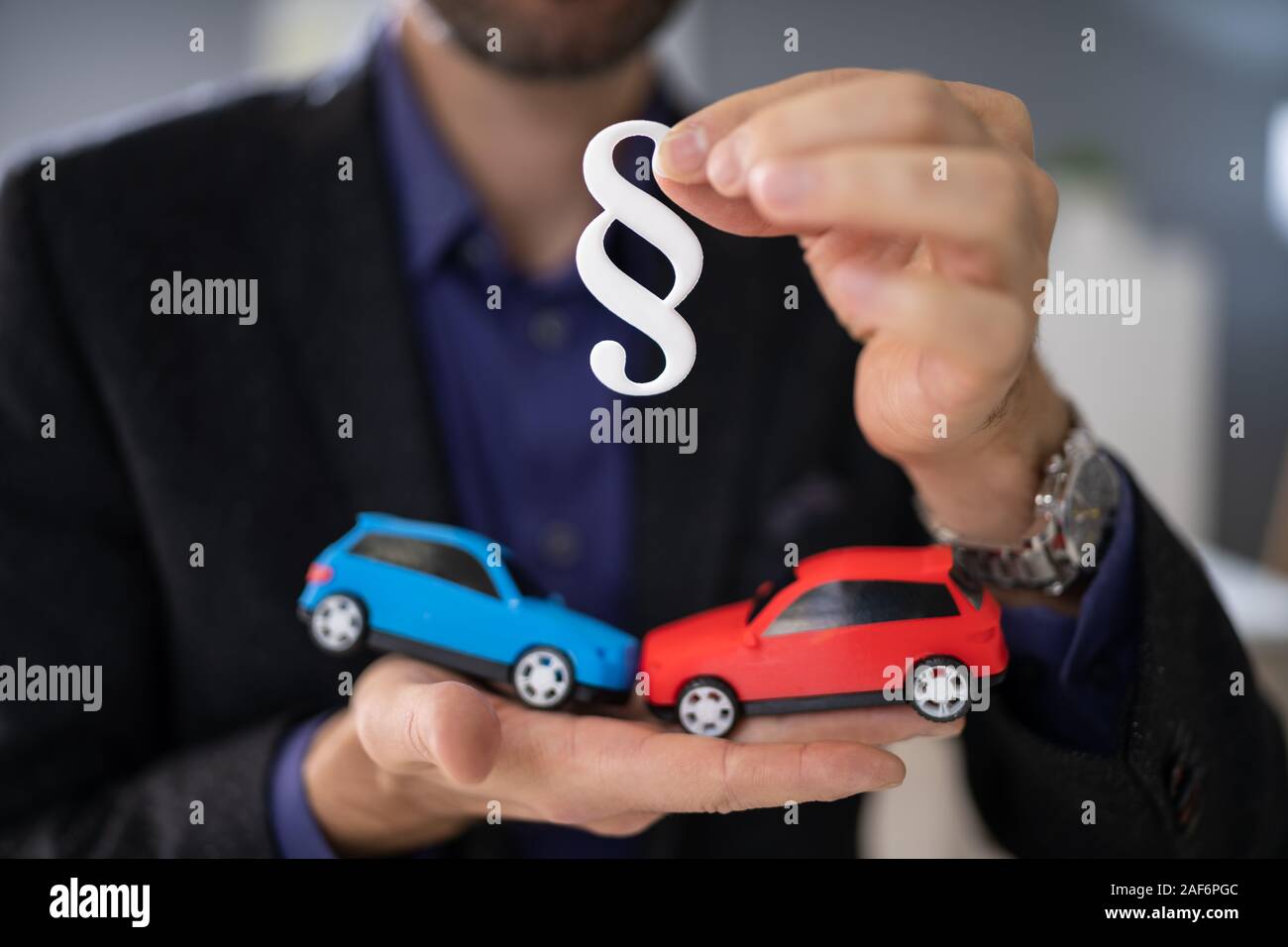 Avocat tenant deux petites voitures en main et Paragraph Sign Banque D'Images