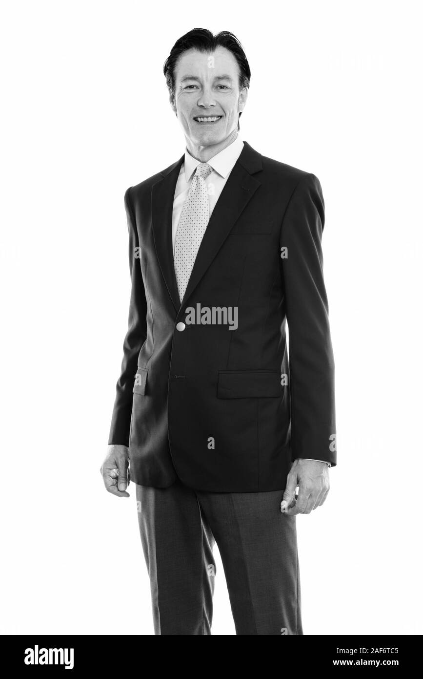 Studio shot of young happy businessman standing in Banque D'Images Studio shot of young happy businessman standing in Banque D'Images