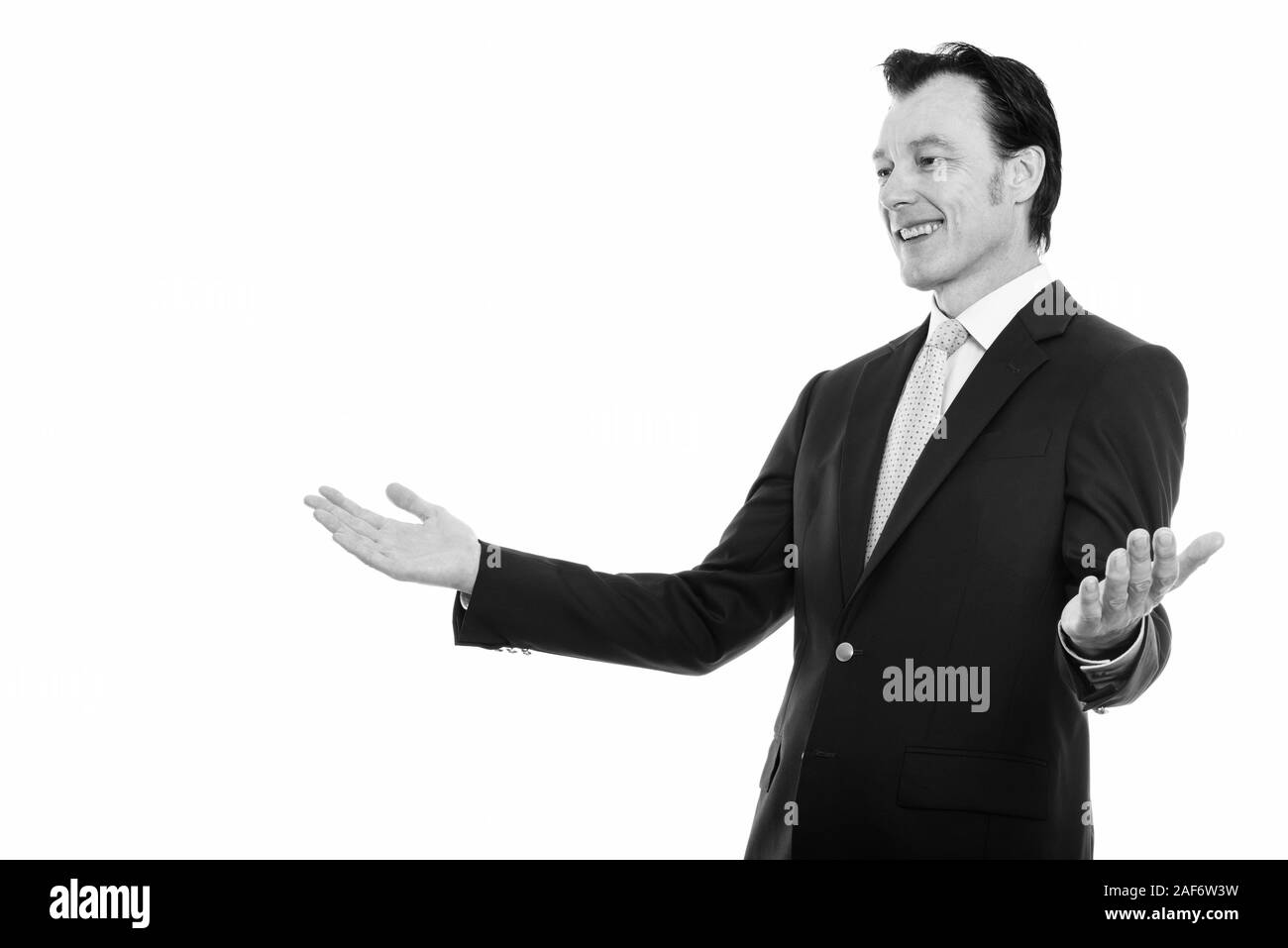 Portrait of happy mature businessman smiling et à la recherche sur le côté à bras ouverts Banque D'Images