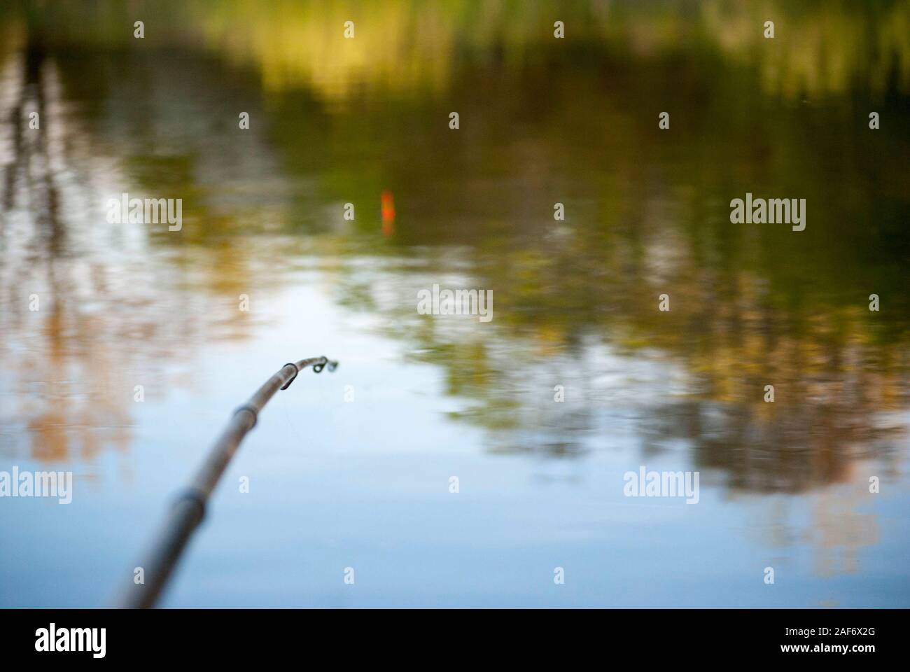 La pointe d'une canne à pêche avec un fond du lac Banque D'Images