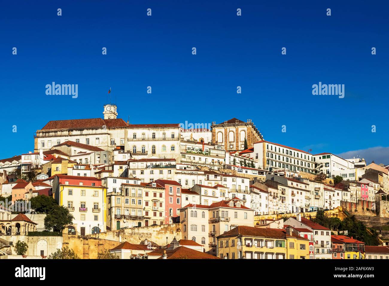 Vue du haut de Coimbra, Portugal, avec ses vieilles maisons sur la colline, à l'Université d'une tour sur une journée ensoleillée avec ciel bleu. Banque D'Images