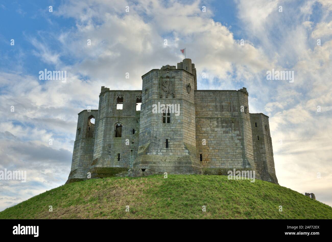 Ruines du donjon et armoiries du château de Warkworth situé sur la colline de premier plan. Northumberland, Angleterre Banque D'Images