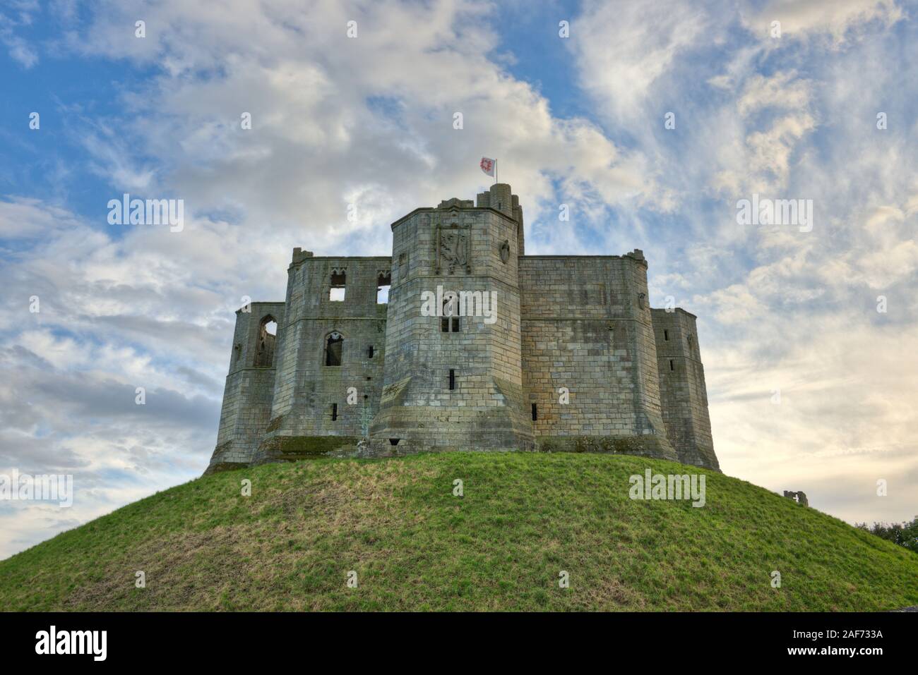 Ruines du donjon et armoiries du château de Warkworth situé sur la colline de premier plan. Northumberland, Angleterre Banque D'Images