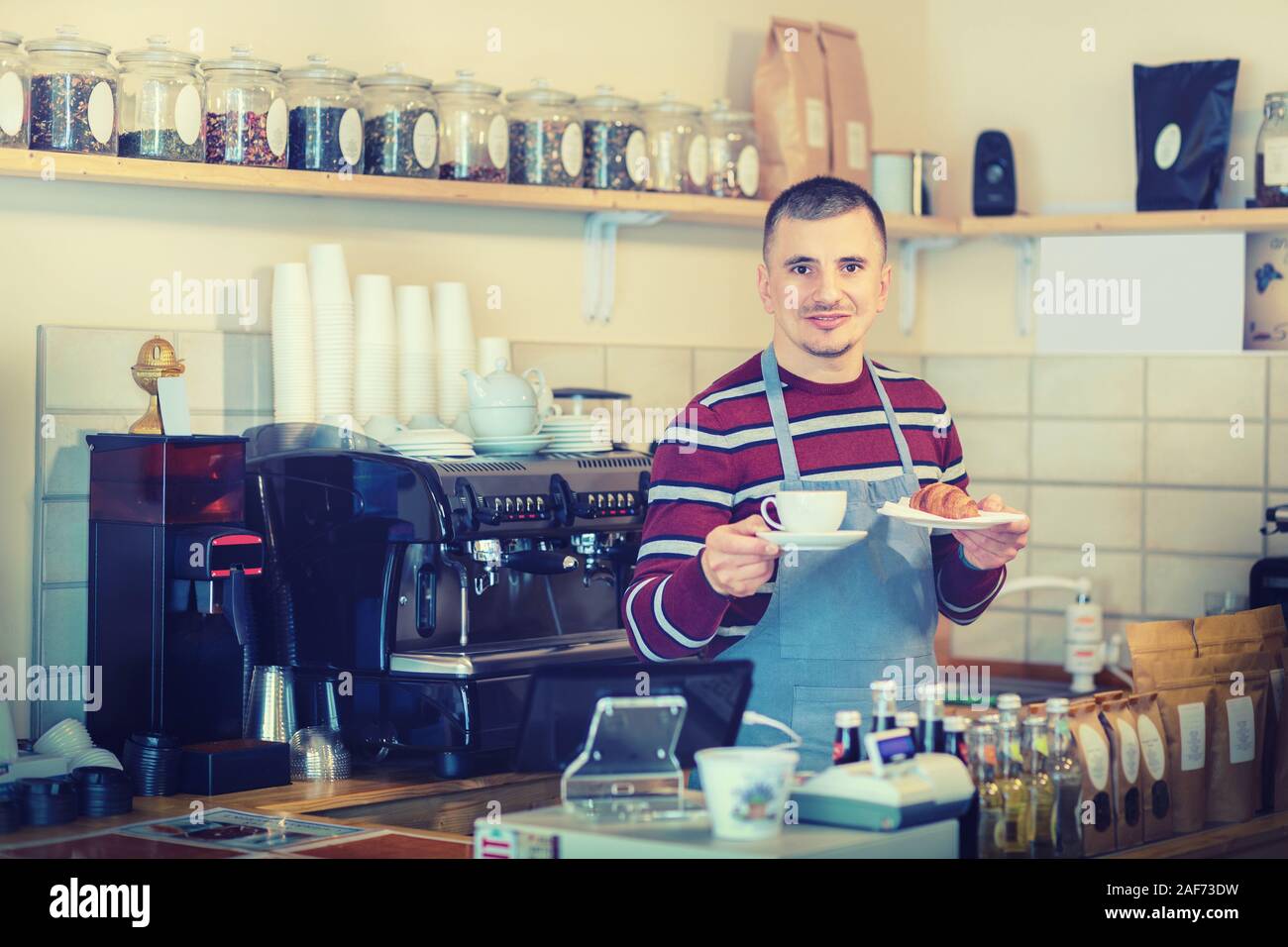 Serveur qui sert le petit-déjeuner avec café et croissant au comptoir de  petit café shop Photo Stock - Alamy