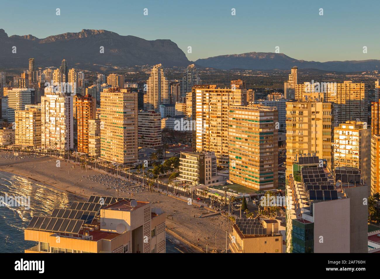 Benidorm Levante Beach promenade au coucher du soleil avec des reflets dans les immeubles de grande hauteur dans le crépuscule de la lumière. Banque D'Images