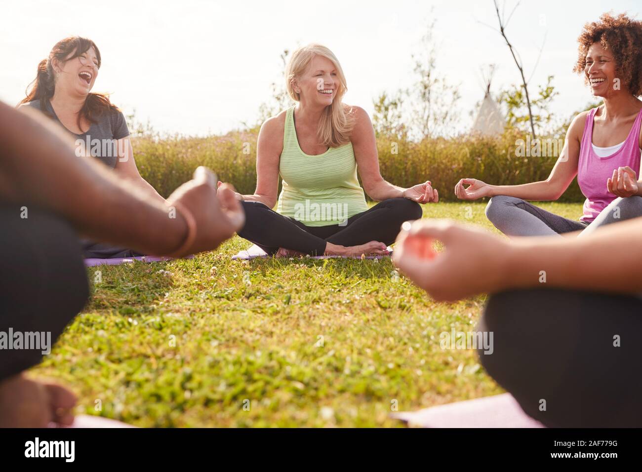 Groupe d'âge Hommes et femmes de sa catégorie dans la retraite de yoga en plein air Cercle assis en méditation Banque D'Images