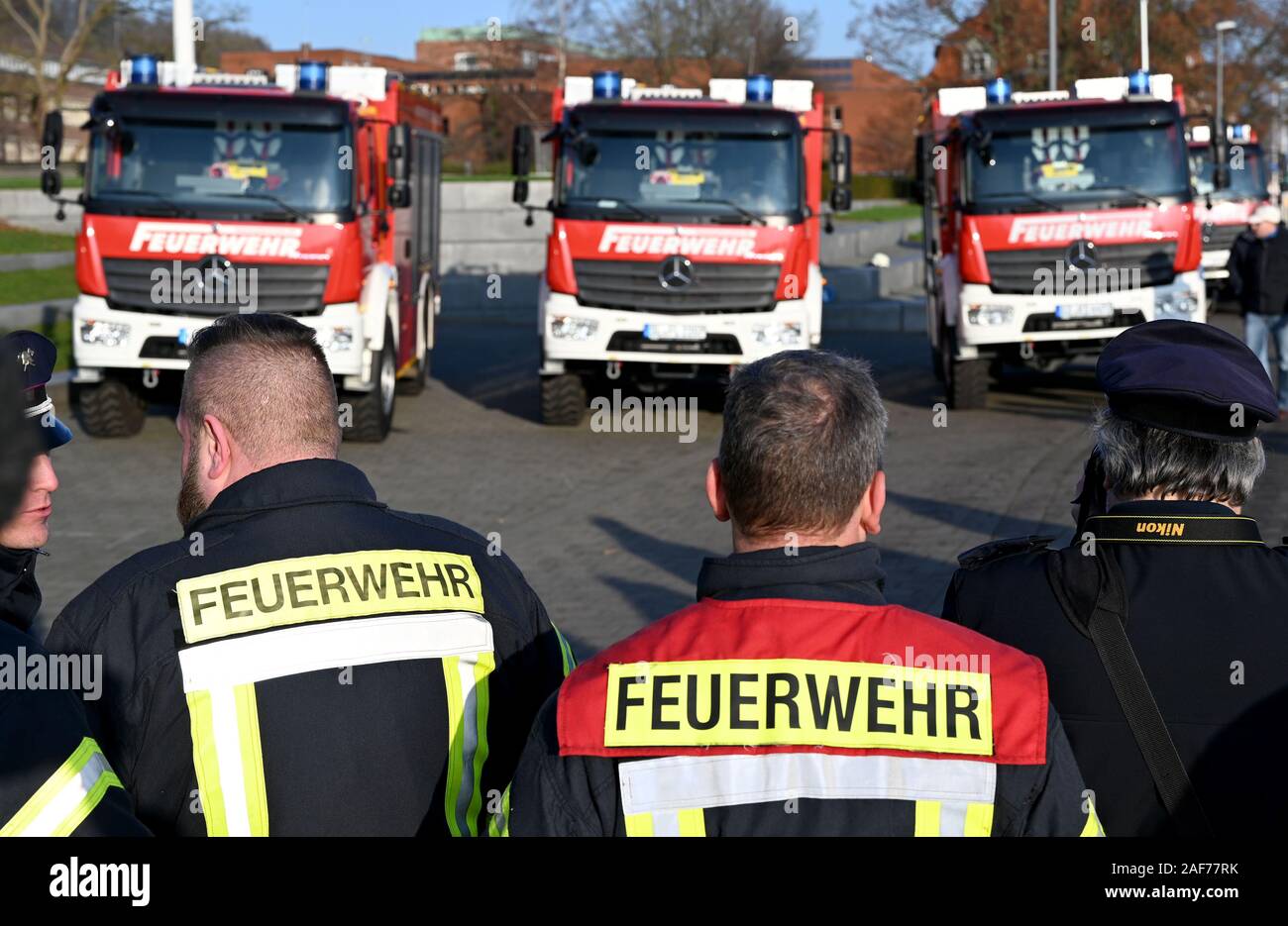 13 décembre 2019, le Schleswig-Holstein, Kiel : Les pompiers sont debout devant de nouveaux véhicules de lutte contre l'incendie pour la lutte contre les catastrophes. Dix camions de pompiers ont déjà été livrés, et en 2024 la flotte est d'être modernisé avec 52 véhicules. En 2027, l'état et les autorités locales ont l'intention d'investir plus de 50 millions d'euros en cas de catastrophe. Photo : Carsten Rehder/dpa Banque D'Images