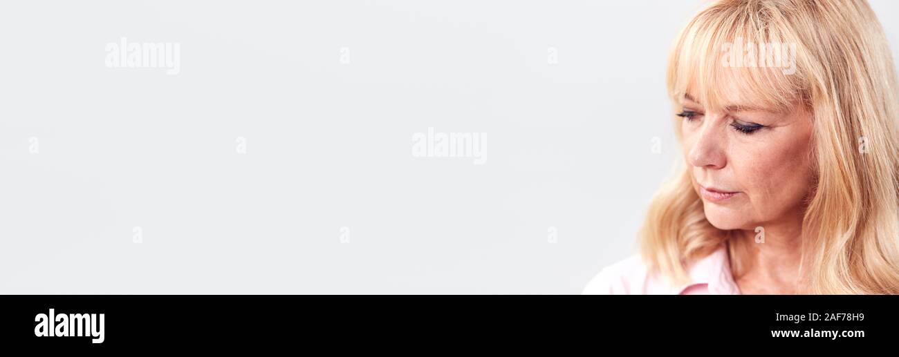 Studio Shot of mécontents et frustrés Mature Woman Against White Background at Camera Banque D'Images