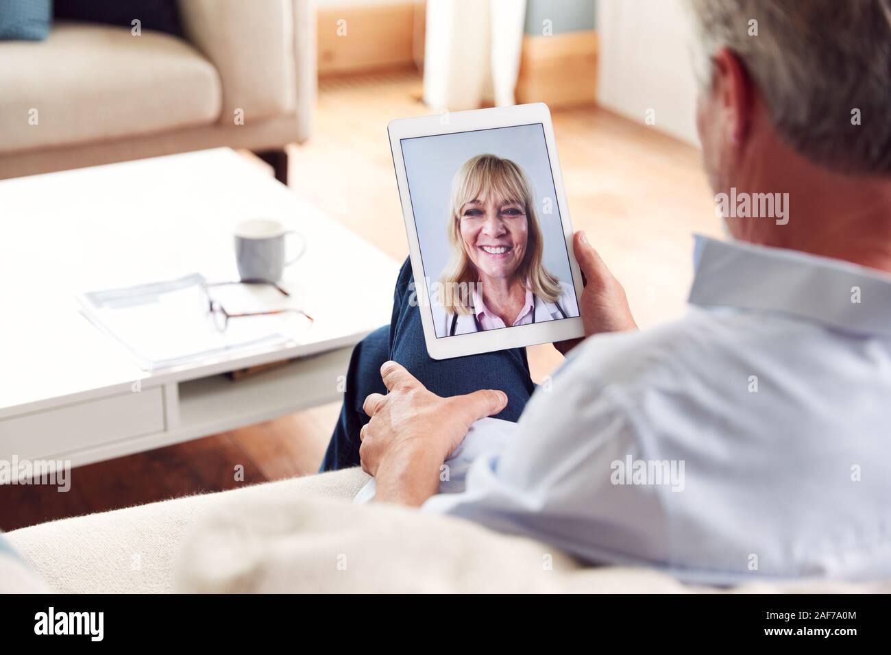 Consultation en ligne mature avec femme médecin à la maison on Digital Tablet Banque D'Images