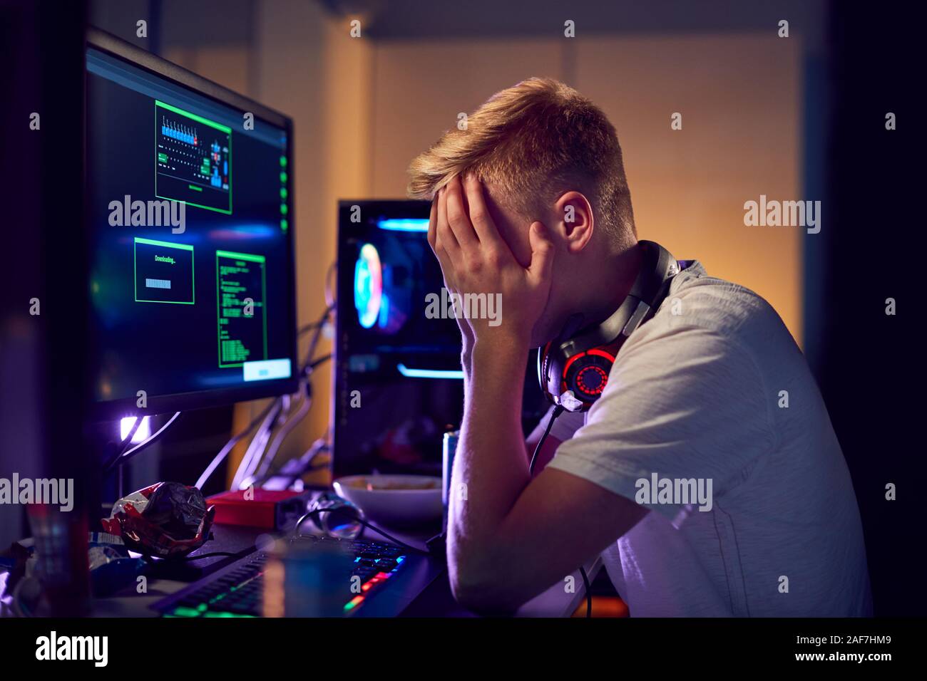 Souligné Teenage Boy étant intimidés en ligne tout en jeu à la maison Banque D'Images