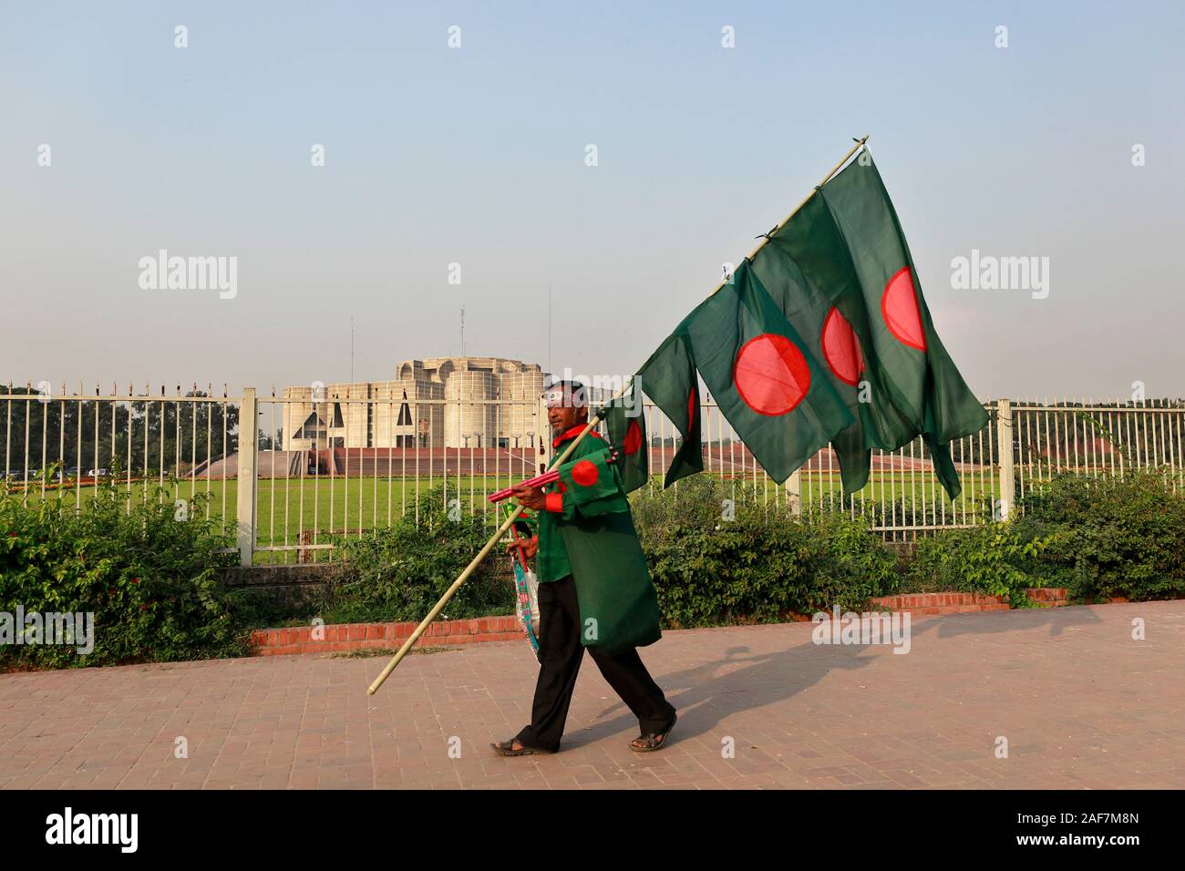 Dhaka, Bangladesh - Décembre 08, 2019 : un homme vend des drapeaux nationaux du Bangladesh en face de l'édifice du parlement national à Dhaka en Bangl Banque D'Images