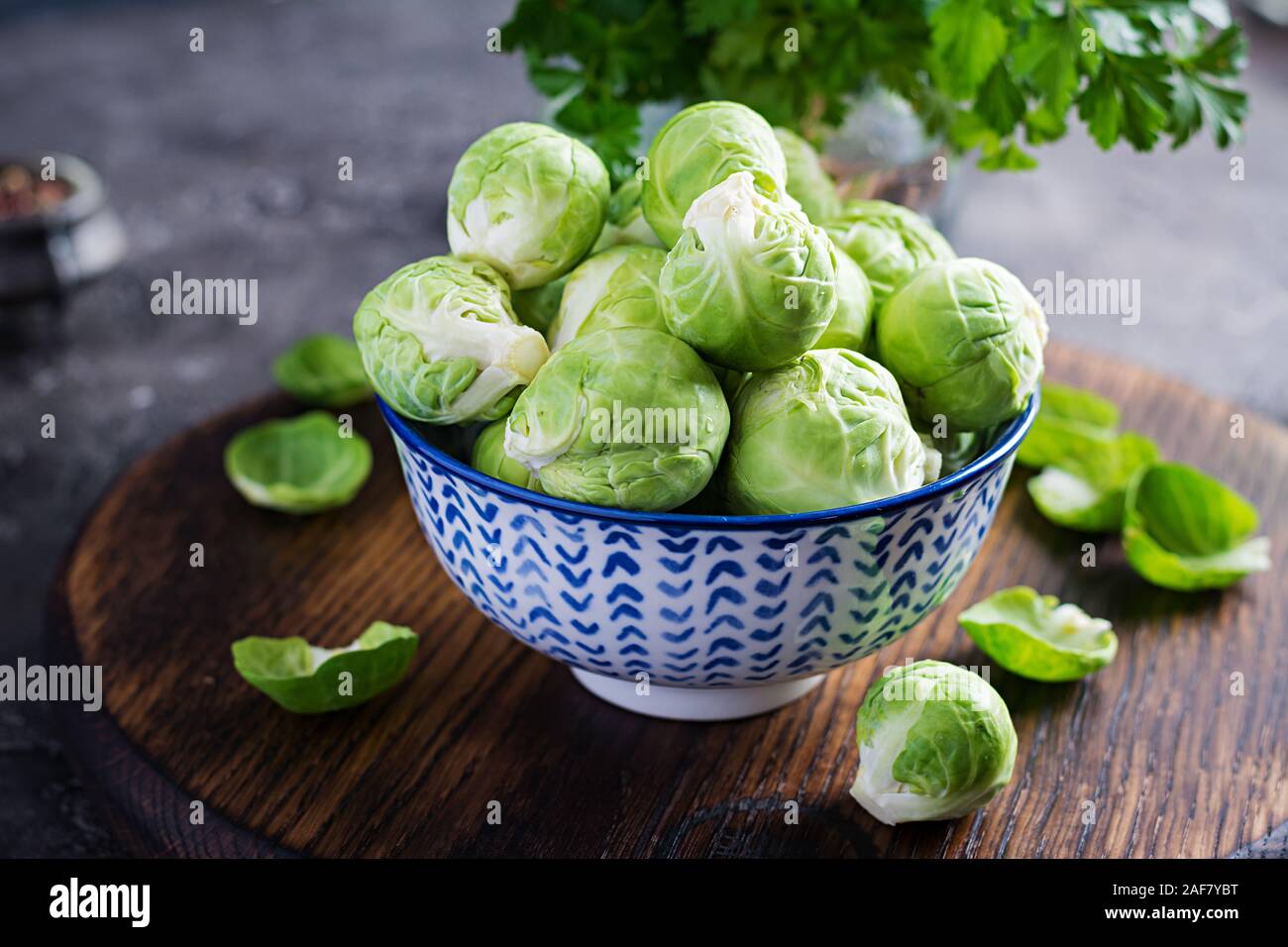 Choux de bruxelles frais biologiques dans un bol sur un fond sombre. Alimentation saine. Repas végétarien/végétalien. Banque D'Images