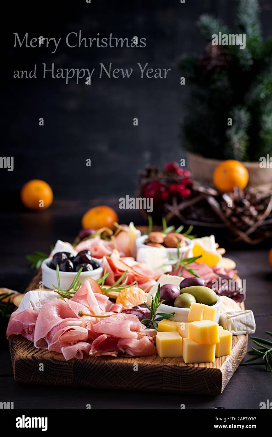 L'antipasto platter avec jambon, jambon, salami, fromage, craquelins et des olives sur un fond de bois. Table de Noël. Banque D'Images