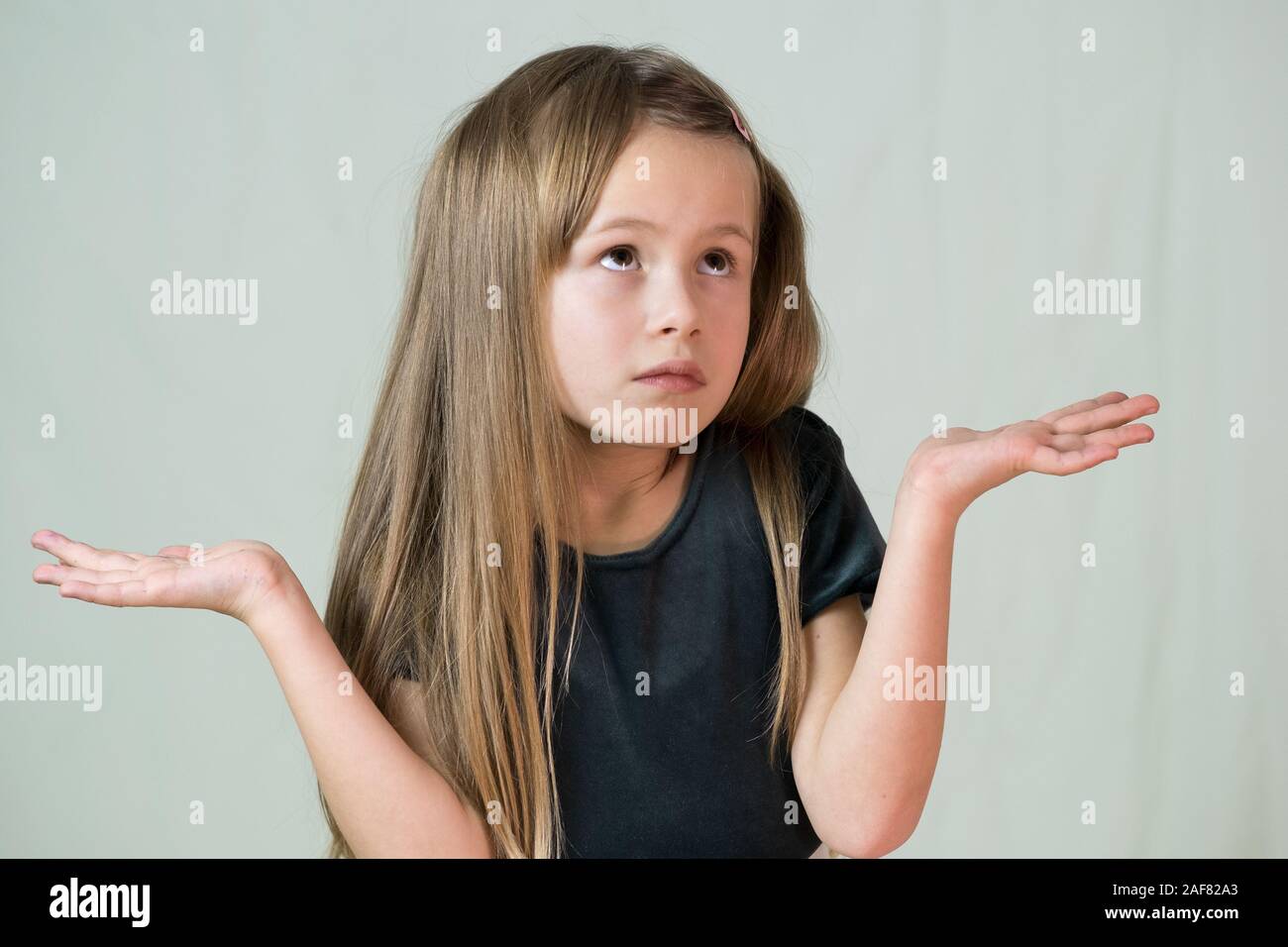 Portrait de jeune fille en haussant les épaules de l'enfant innocent qui je ne connais pas l'expression. Banque D'Images