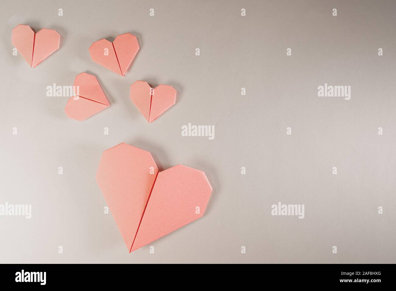 Origami rose coeurs sur un fond de papier Banque D'Images