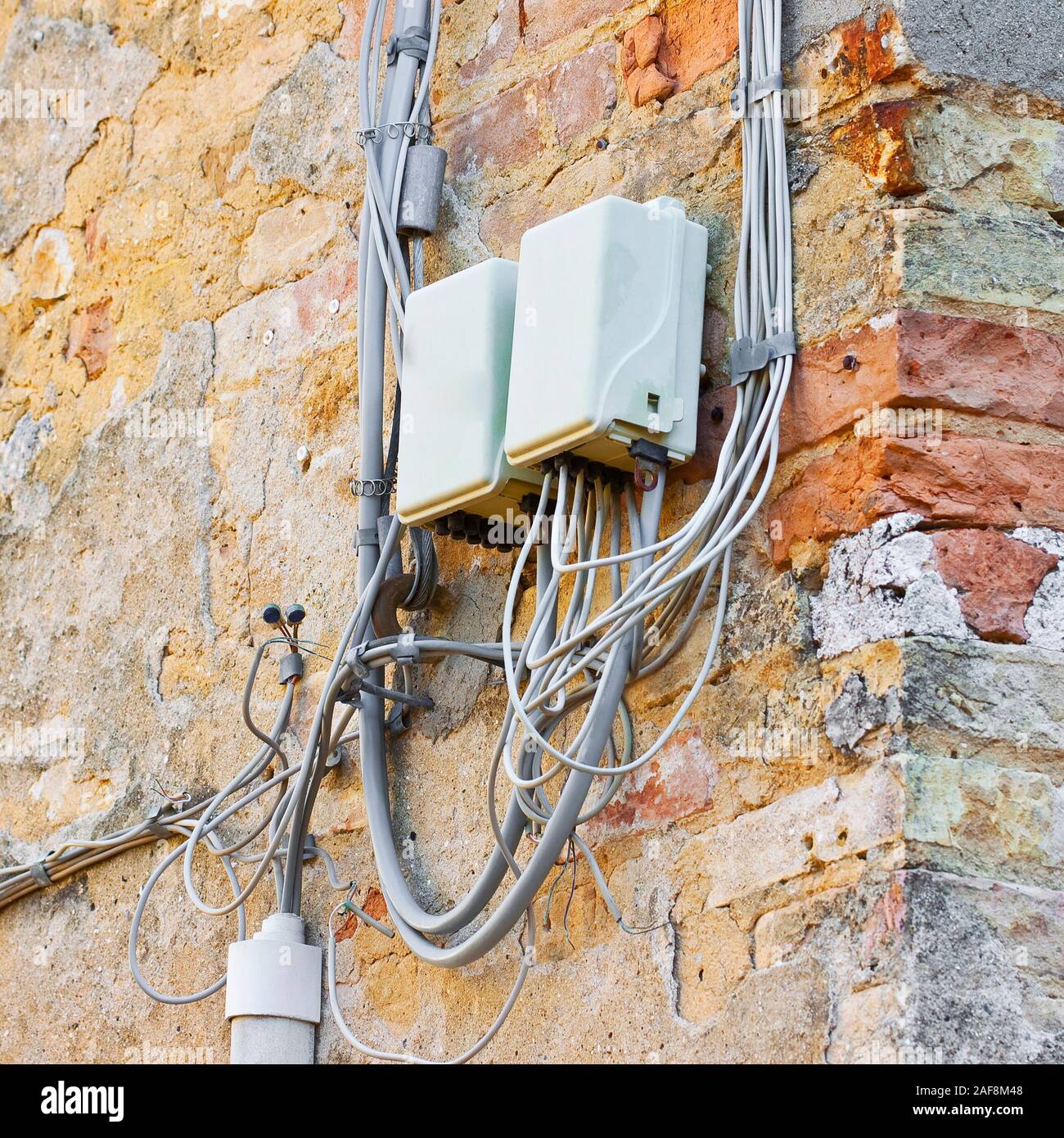 Les câbles téléphoniques environ assemblée avec boîte de jonction en  plastique contre un vieux mur de plâtre Photo Stock - Alamy