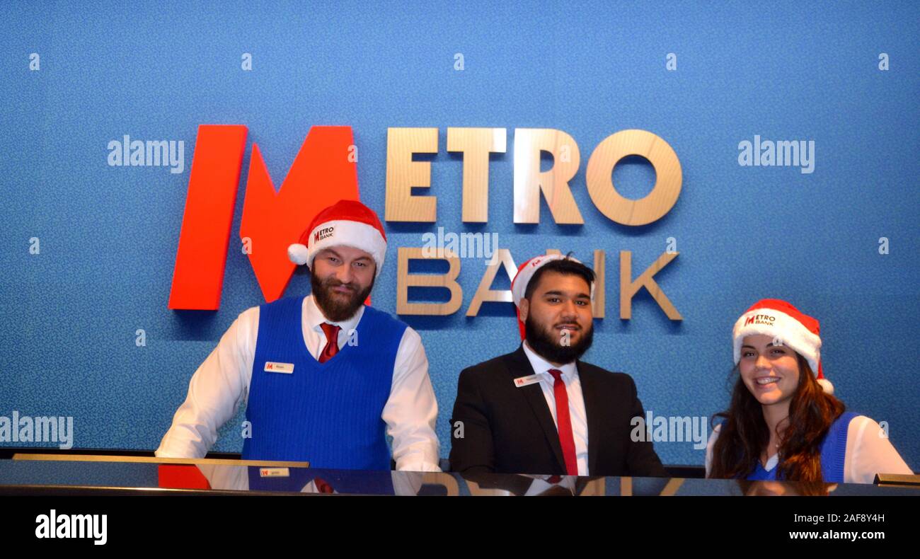 Le 13 décembre, 2019, Metro Bank ouvre une nouvelle succursale à Market Street, Manchester, Royaume-Uni. Personnel porte des chapeaux de Noël pour accueillir les clients. Banque D'Images