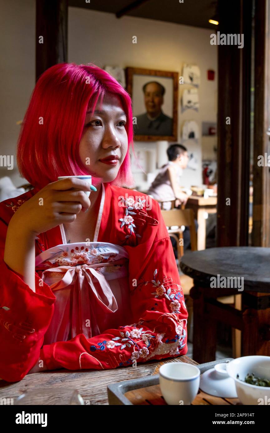 Une jeune femme chinoise à la mode buvant du thé et portant une tunique  chinoise traditionnelle Photo Stock - Alamy