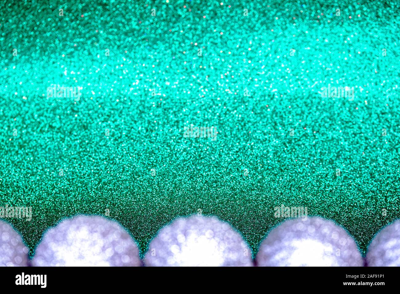 L'argent flou artistique des décorations de Noël sur fond vert turquoise du golfe de Gascogne. Banque D'Images