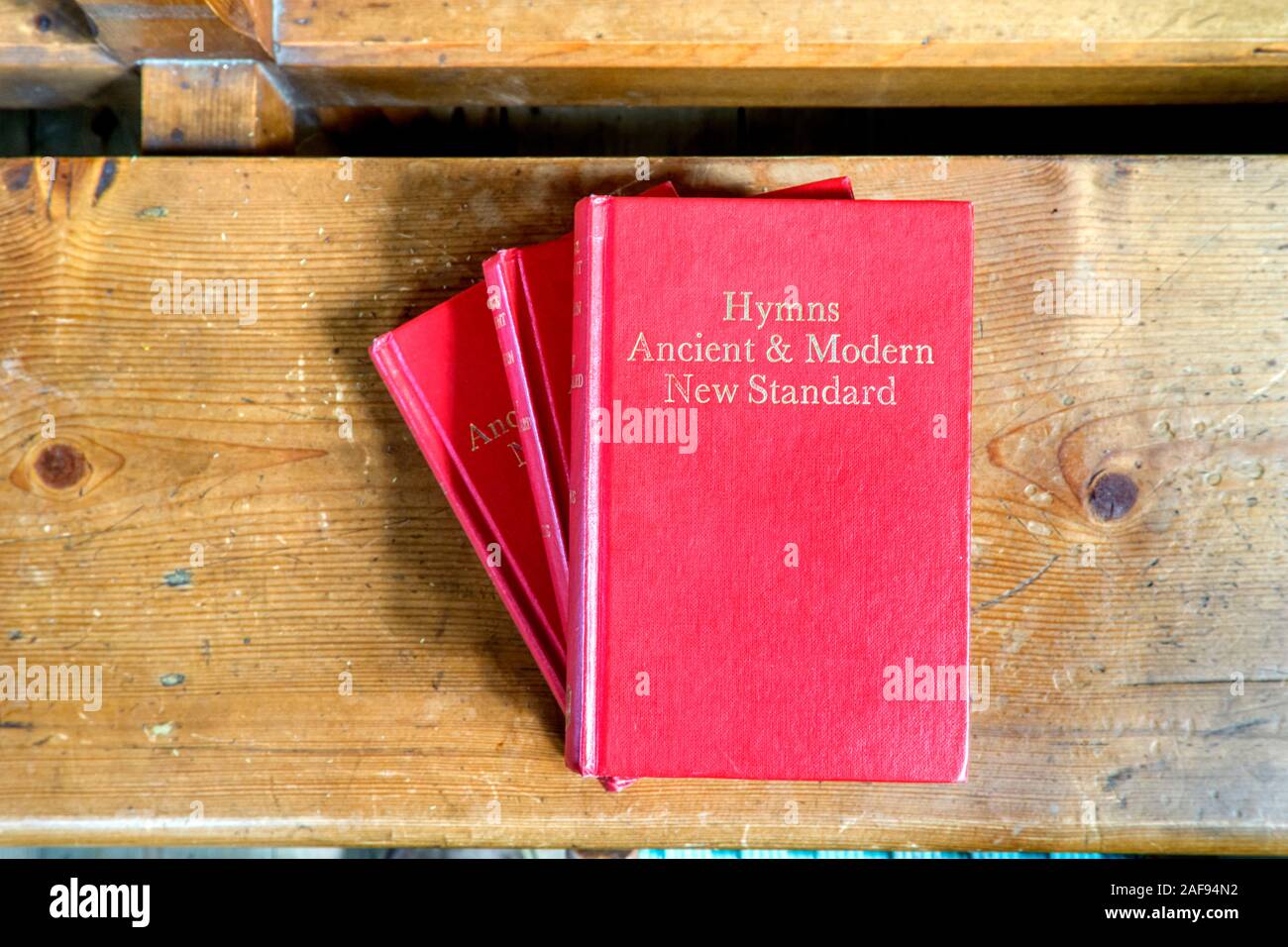 Une pile d'hymnes ancienne et moderne sur une église pew. Banque D'Images