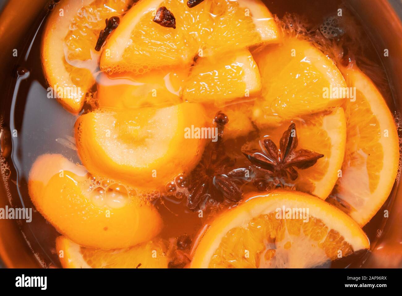 La préparation de boissons vin chaud avec des oranges et des épices. Les boissons de Noël faire bouillir dans le moule en métal. Glintwine de vin rose avec des agrumes, de girofle Banque D'Images