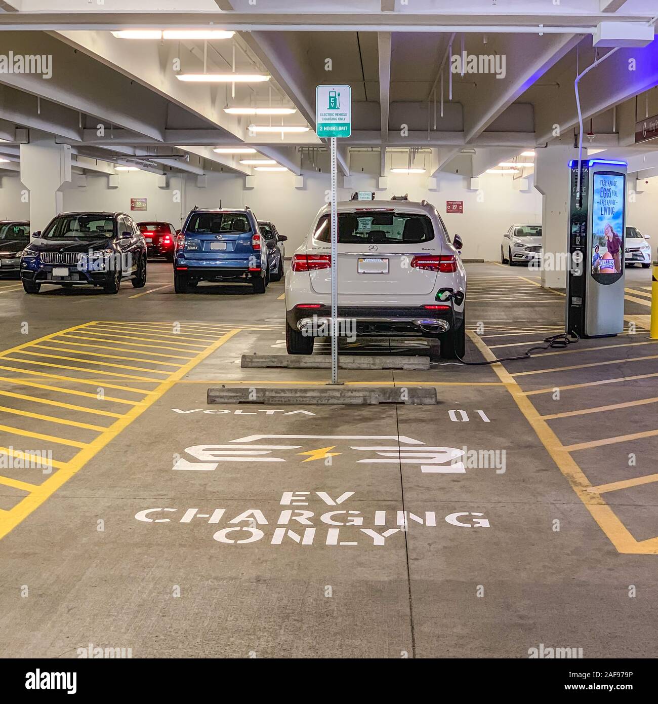 La charge de la batterie du véhicule électrique en magasin d'un garage de stationnement. Alexandria, Virginia, USA. Banque D'Images