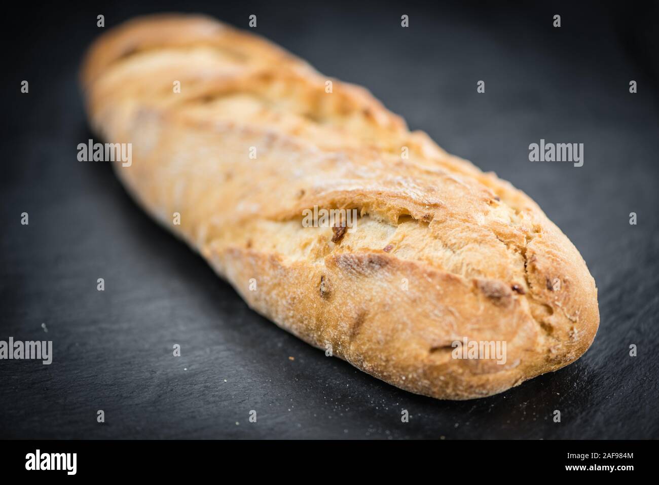 La baguette sur une dalle d'ardoise vintage (close-up shot, selective focus) Banque D'Images