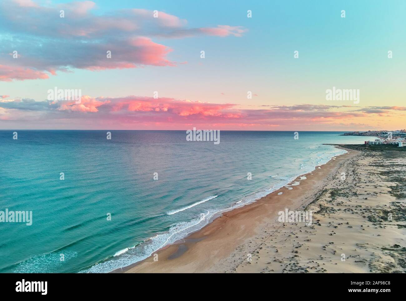 Paysage pittoresque vue aérienne drone paysage, bleu calme mer Méditerranée coloré doux nuages roses brillant au coucher du soleil ciel soir, Espagne Banque D'Images
