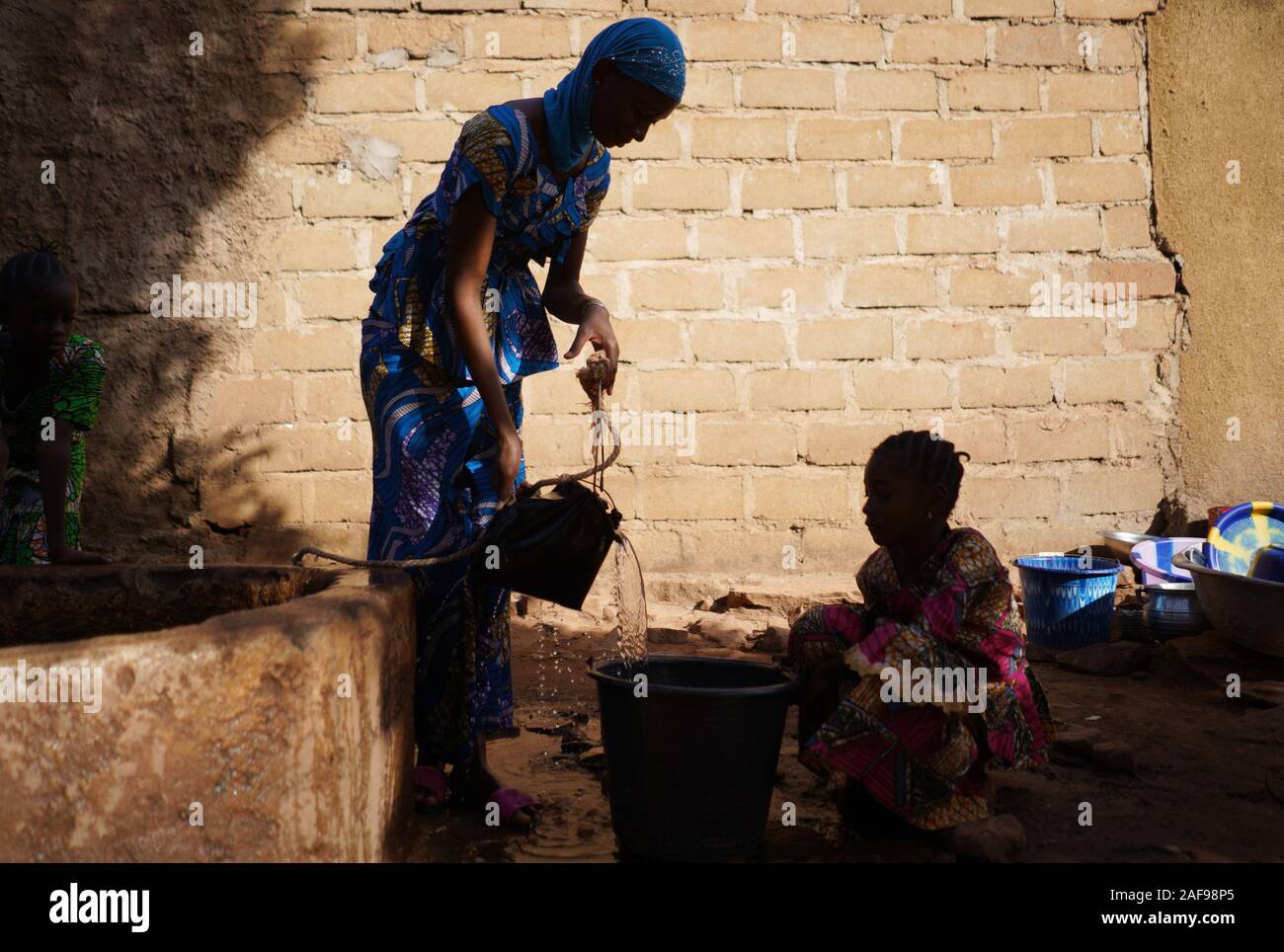 Les écolières de l'Afrique à la collecte de l'eau de puits au Mali Banque D'Images