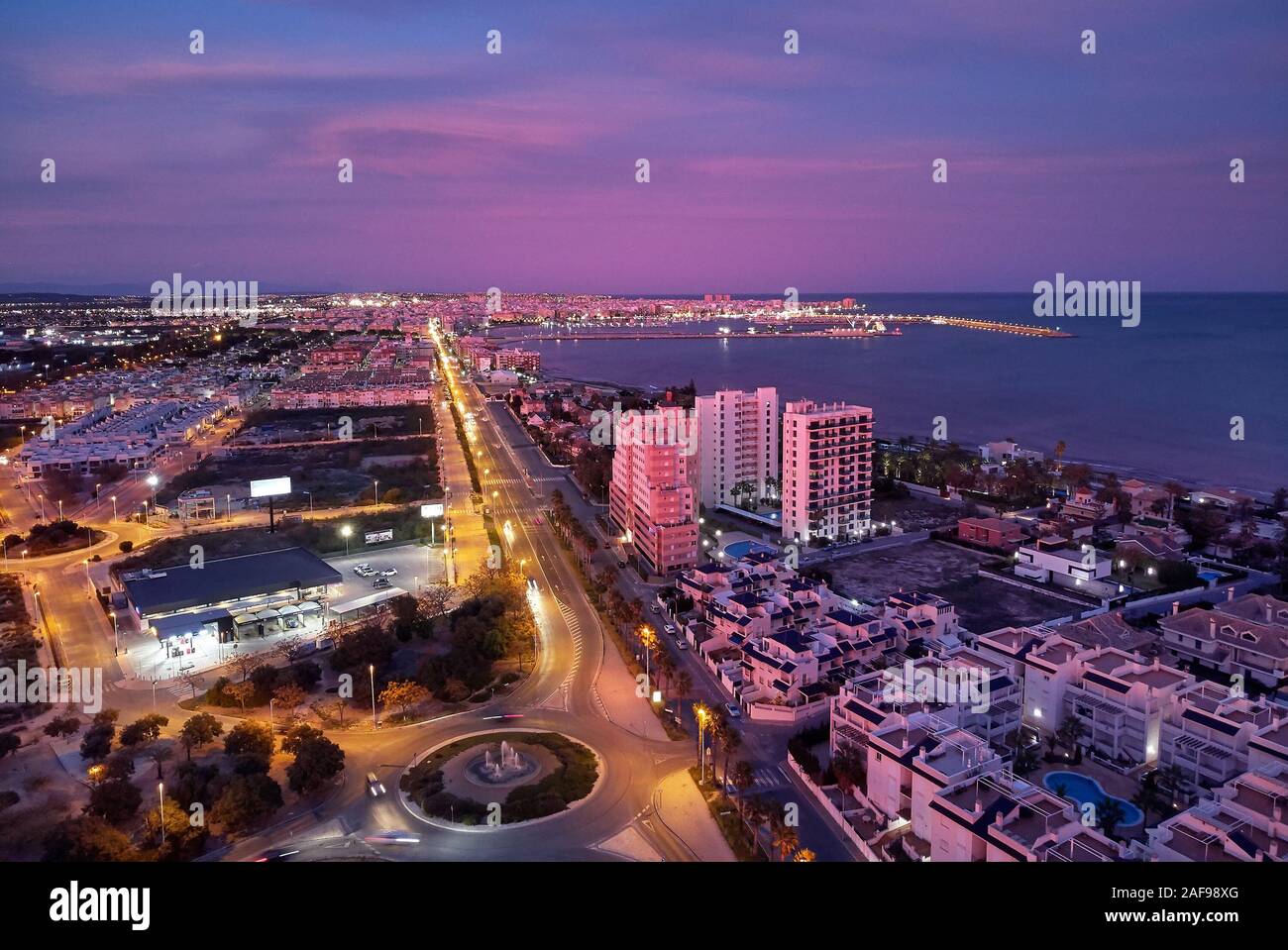 Photo aérienne Vue de dessus de Torrevieja ville espagnole pendant le coucher du soleil pourpre violet couleur ciel nuageux, coucher de soleil pittoresque, Province d'Alicante, le coût Banque D'Images